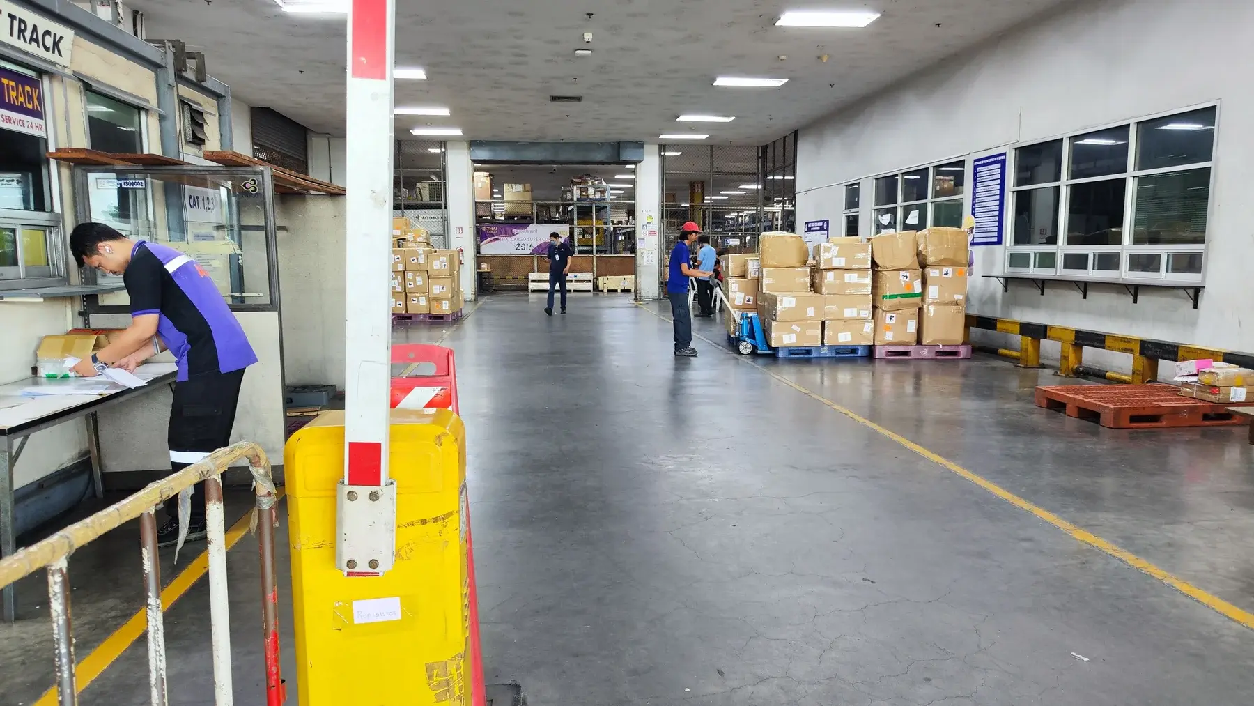 Staff handling paperwork and shipments inside the cargo terminal