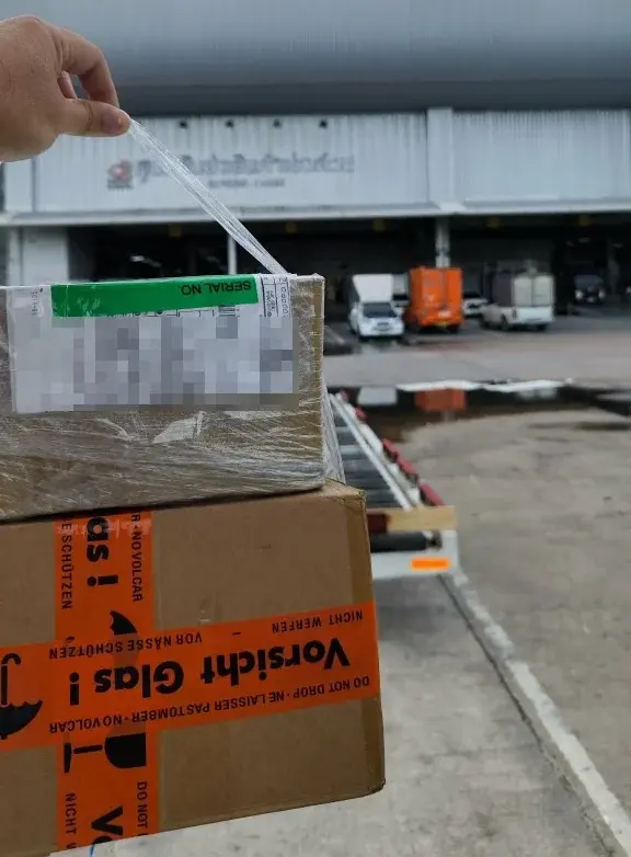 Released courier parcels outside the cargo terminal, with address details concealed